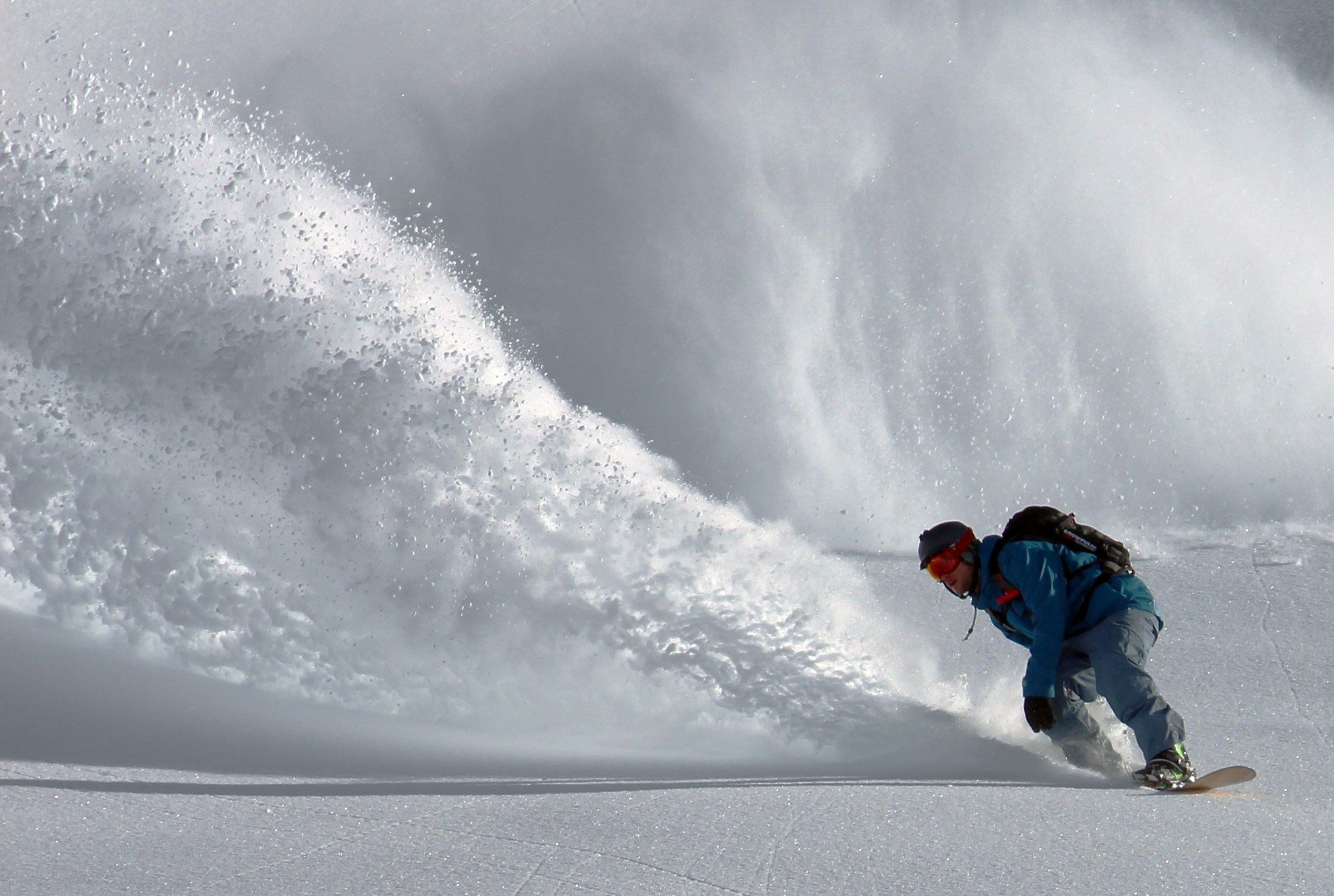 Skier carving a turn through fresh deep powder snow