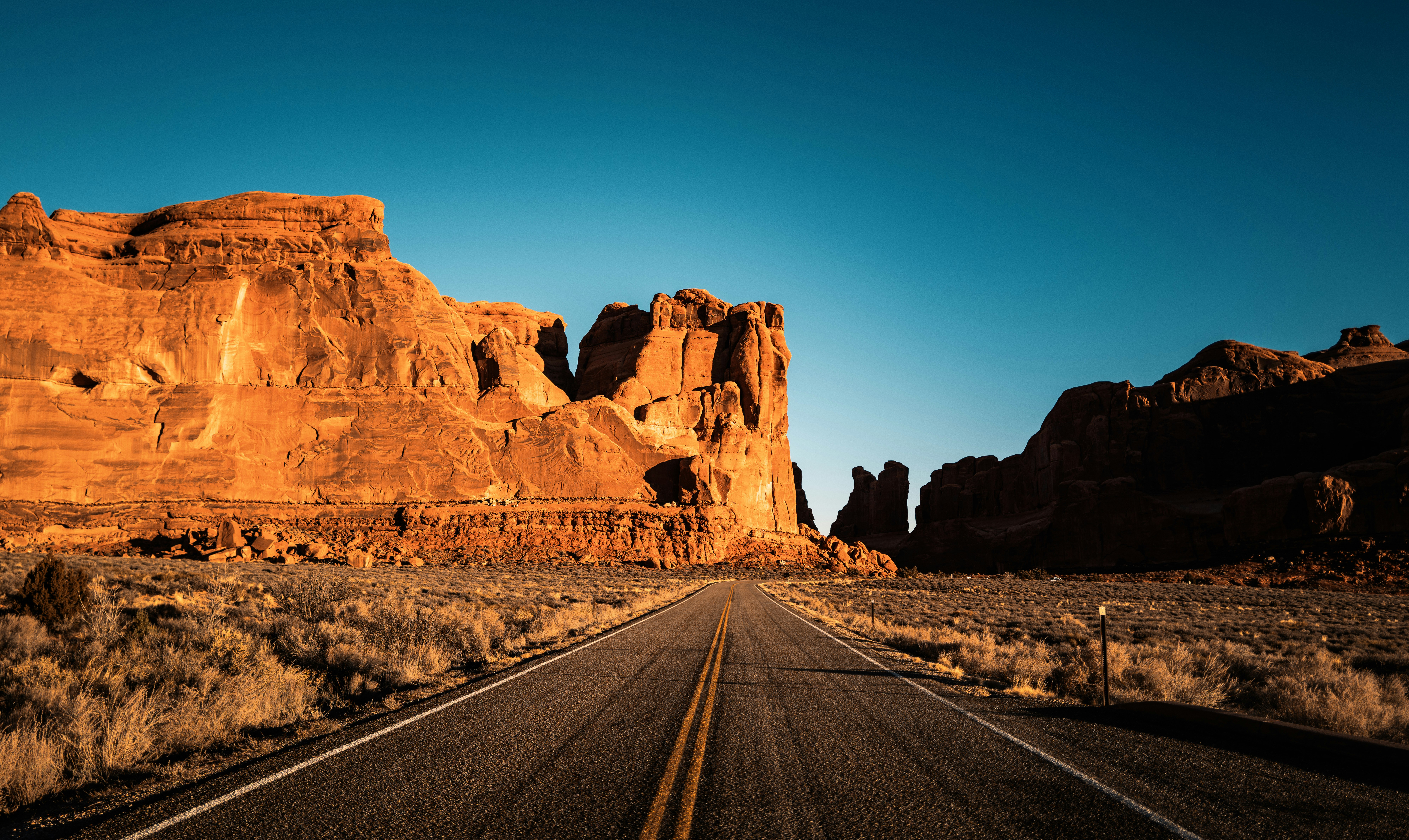 Desert road winding through southern Utah sandstone rock formations near the Kanab region