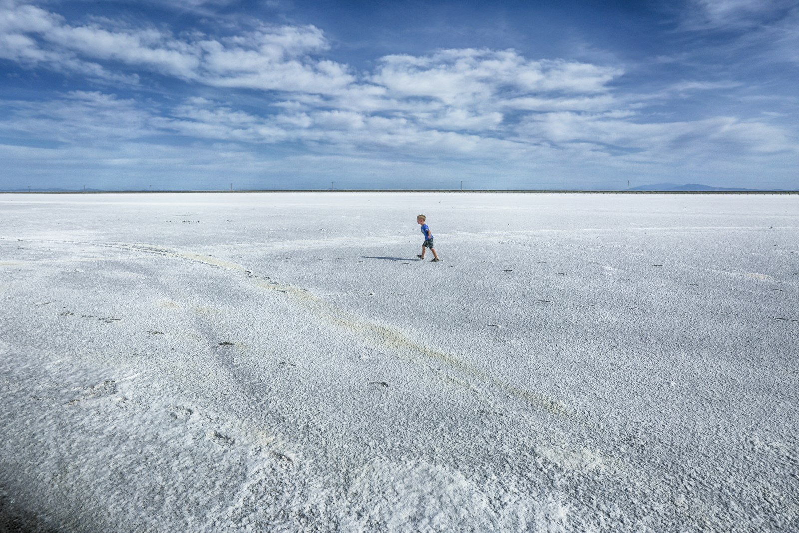 A visitor walking across the white salt crust of the Bonneville Salt Flats, Utah