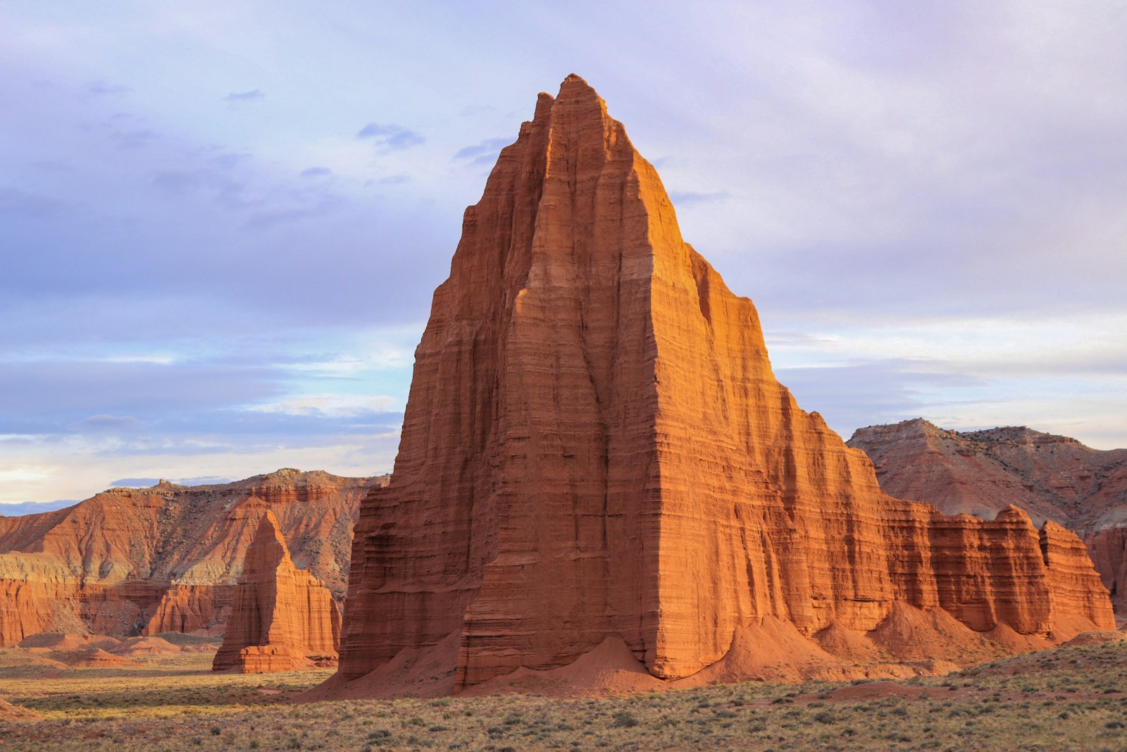 Tall sandstone monolith in Capitol Reef National Park glowing in warm sunset light