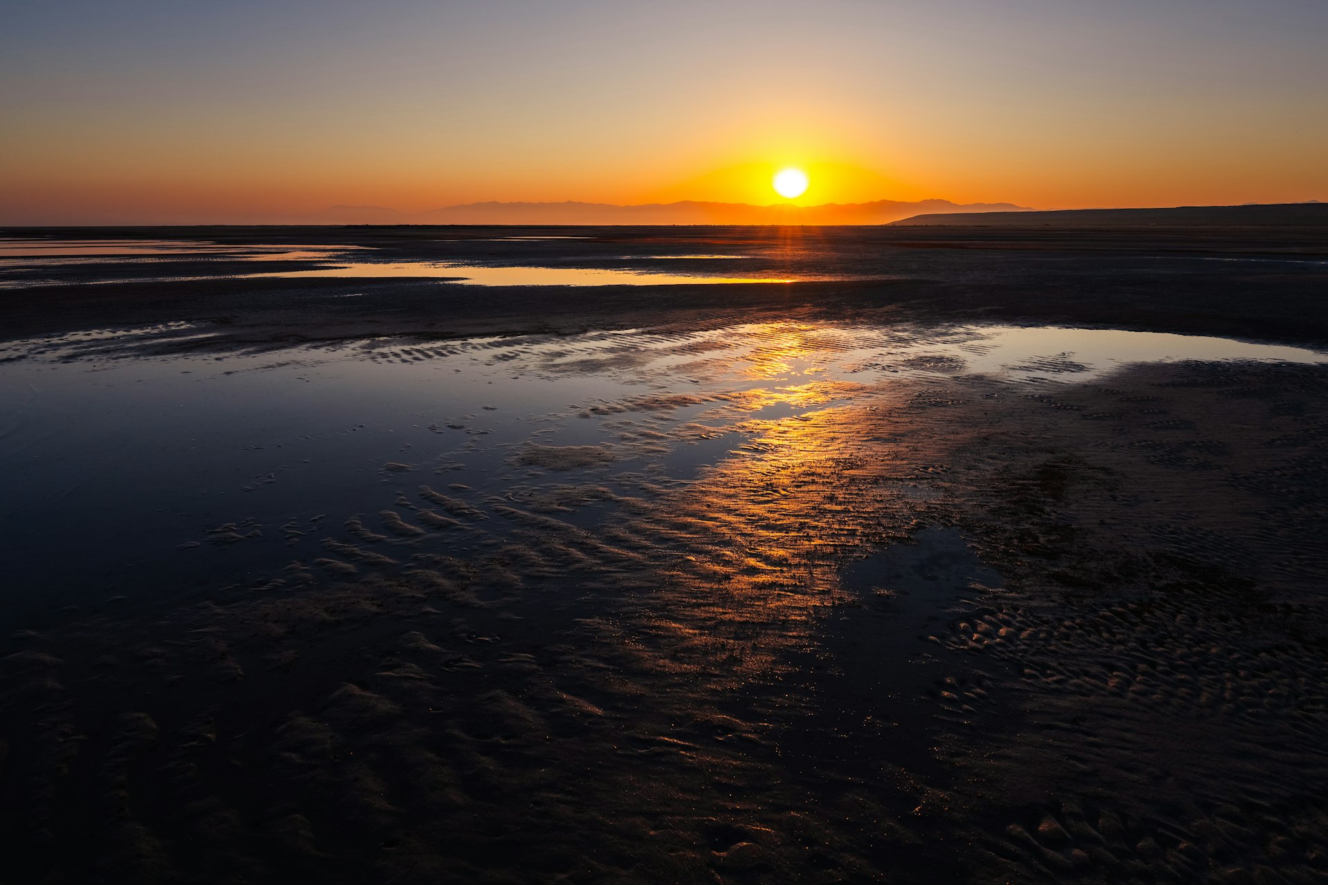 Golden sunset over the Great Salt Lake near Salt Lake City, Utah, with distant mountain silhouettes